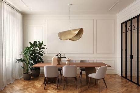 Elegant dining room with wood table, plush chairs, and a sculptural pendant light.
