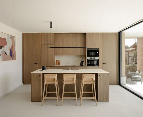 Sleek, minimalist kitchen design with wooden cabinetry, clean countertops, and modern appliances.