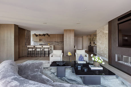 Expansive, modern living space with wood paneling, marble accents, and sleek furnishings.