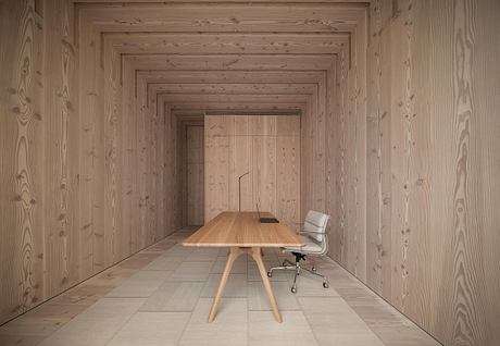 A spacious wooden-paneled room with a minimalist table and chair, showcasing a clean, modern design aesthetic.