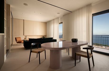 Spacious modern dining room with minimalist furniture and stunning ocean view.