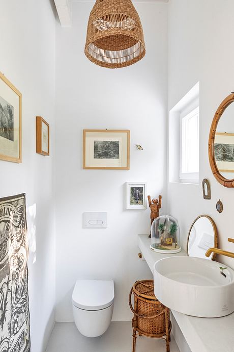 Rustic bathroom with woven light fixture, framed artwork, and natural materials.