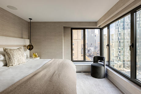 Minimalist bedroom with floor-to-ceiling windows overlooking the city skyline.