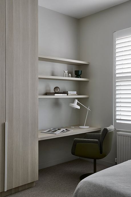 Minimalist bedroom design with built-in shelving, desk, and neutral color palette.