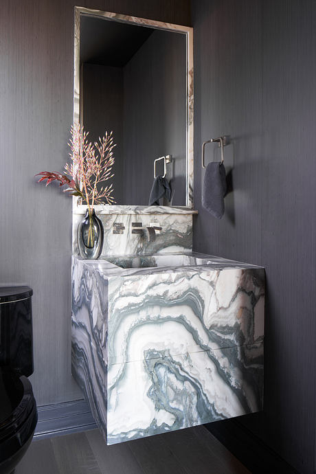 Elegant marble vanity with minimal fixtures and striking floral decor in dark bathroom.