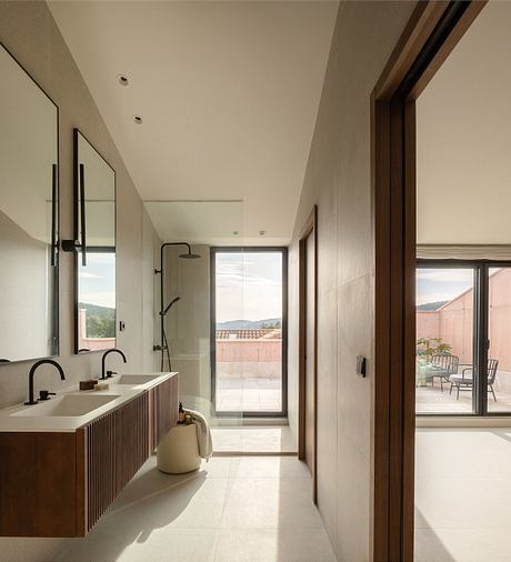 Minimalist bathroom with wooden vanity, large window, and access to outdoor terrace.