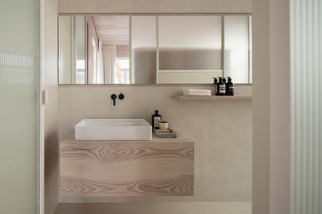 Minimalist bathroom design with floating vanity, rectangular vessel sink, and large wall mirror.