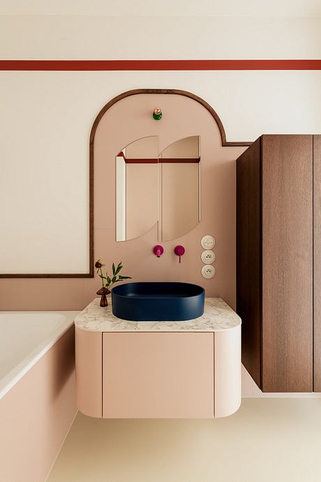 A minimalist bathroom design with a marble countertop, a navy blue vessel sink, and a built-in mirror.