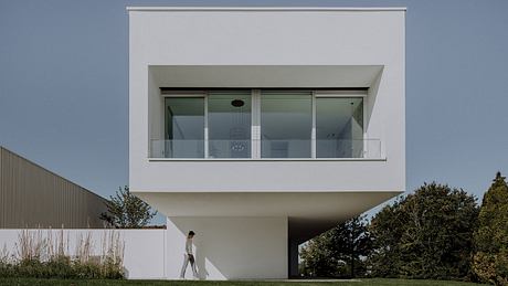 Sleek, minimalist modern home with large glass windows and clean, geometric exterior.