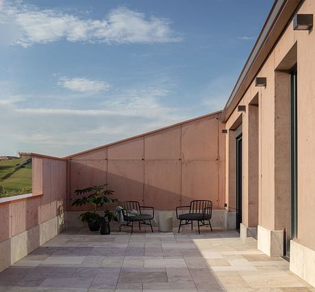 Spacious outdoor terrace with tiled flooring, potted plant, and modern seating.