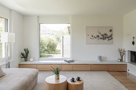 Sleek, minimalist living room with large window, wood media console, and nature-inspired decor.