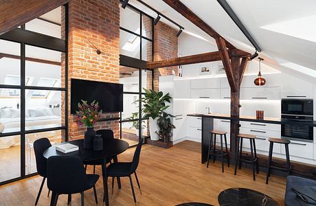 Exposed brick walls, wooden beams, and modern kitchen design in an open-concept loft.