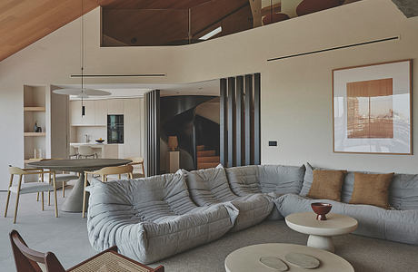 Spacious modern living room with vaulted ceiling, plush sectional, and sleek furnishings.