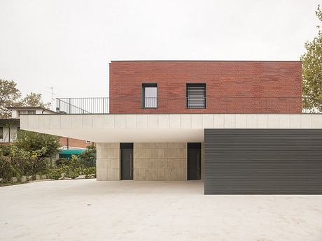 Contemporary brick and stone facade with minimalist windows and covered entryway.