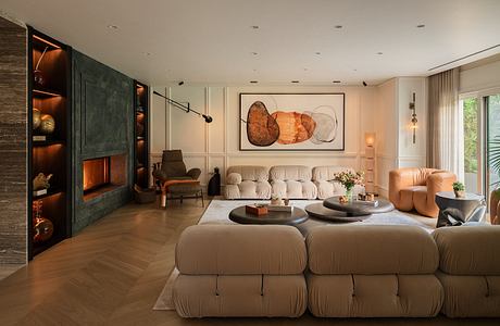 Cozy living room with plush modular seating, wood-paneled fireplace, and abstract artwork.