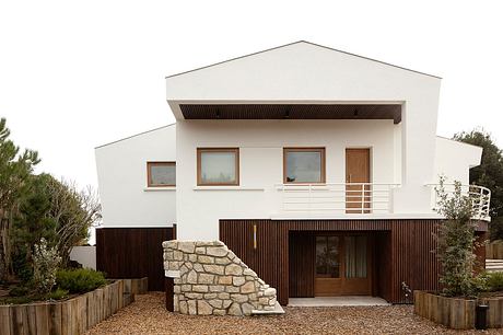 Striking contemporary home with stone, wood, and metal accents. Distinctive architectural features.