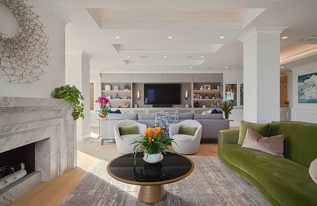 Bright, modern living room with built-in cabinetry, marble fireplace, and colorful furnishings.