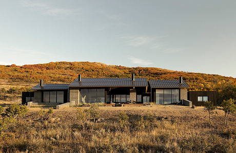 A contemporary desert retreat with sleek black exteriors and large windows offering panoramic views.