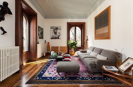 Elegant living room with ornate ceiling, wood trim, and eclectic furnishings.