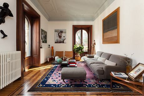 Elegant living room with ornate ceiling, wood trim, and eclectic furnishings.