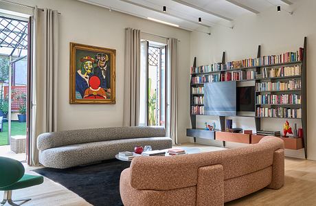 Stylish living room with built-in bookshelves, large artwork, and modern furniture.