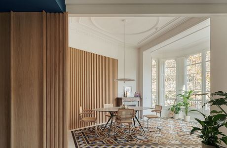 Elegant entry with ornate moldings, wooden wall paneling, and patterned tile floor.