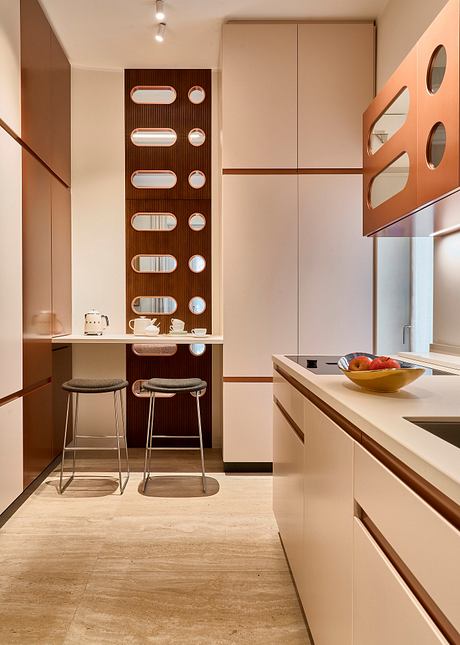 A modern kitchen with clean lines, warm wood tones, and built-in storage and displays.