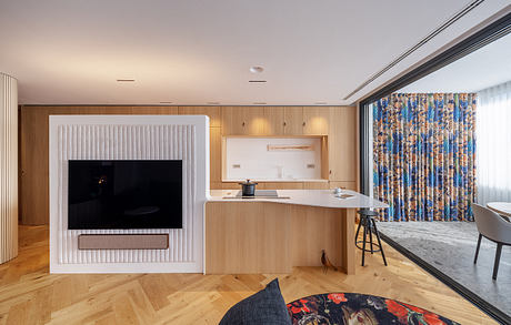 Modular, light-filled interior with geometric fireplace, wood panels, and patterned curtains.