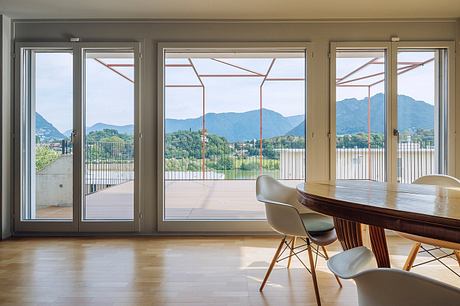 Spacious room with large windows offering panoramic views of mountainous landscape.