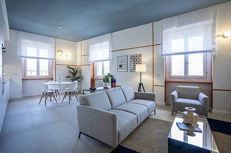 Bright, modern living room with minimalist furnishings, large windows, and neutral color palette.