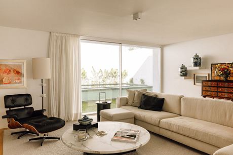 Serene living room with large windows, neutral color palette, and modern furnishings.