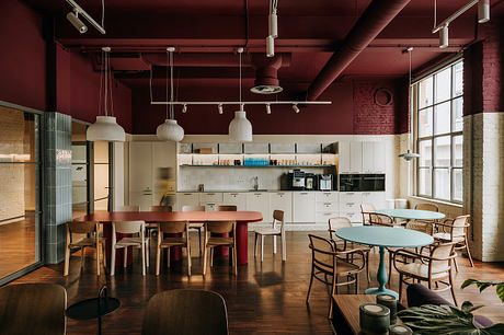 Large open-plan kitchen and dining area with exposed brick, modern lighting, and colorful furniture.