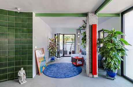 Vibrant, modern interior with green accents, bold artwork, and lush greenery complementing the architectural elements.