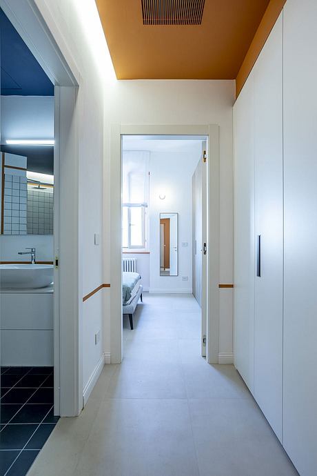 Spacious hallway with wooden accents, leading to a cozy bedroom and modern bathroom.