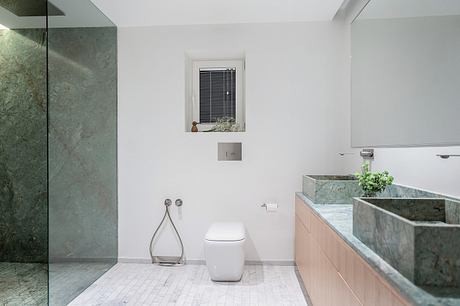 Contemporary bathroom design with sleek marble vanity and wall-mounted toilet.