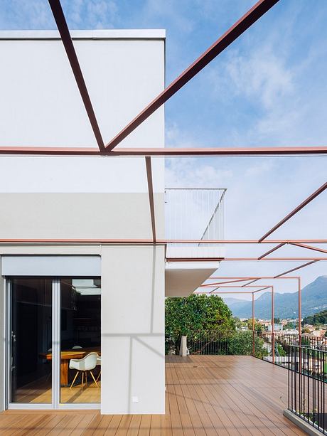 Modern architectural design with clean lines, large windows, and a spacious outdoor deck with a view.