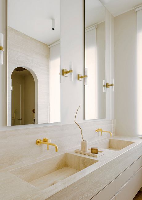 A modern bathroom with clean lines, white marble surfaces, and gold fixtures.