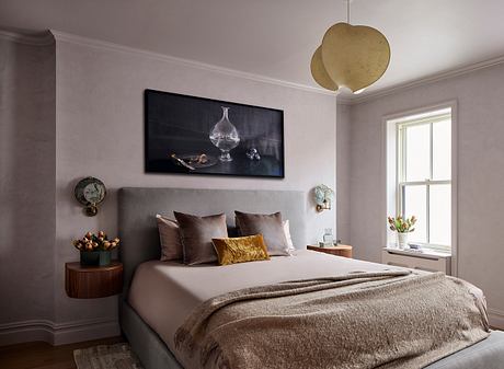 A cozy, well-designed bedroom with muted tones, plush textures, and a striking artwork.