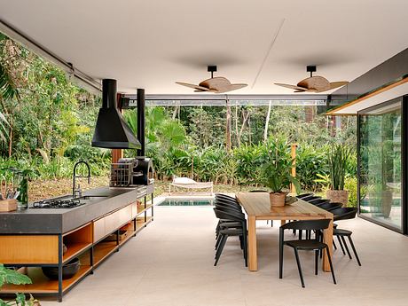 Sleek, nature-inspired kitchen and dining area with wood and glass elements.