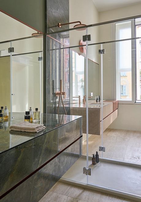 Luxurious bathroom with sleek glass enclosure, marble vanity, and modern fixtures.