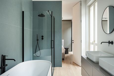Modern minimalist bathroom with freestanding bathtub, shower enclosure, and sleek fixtures.