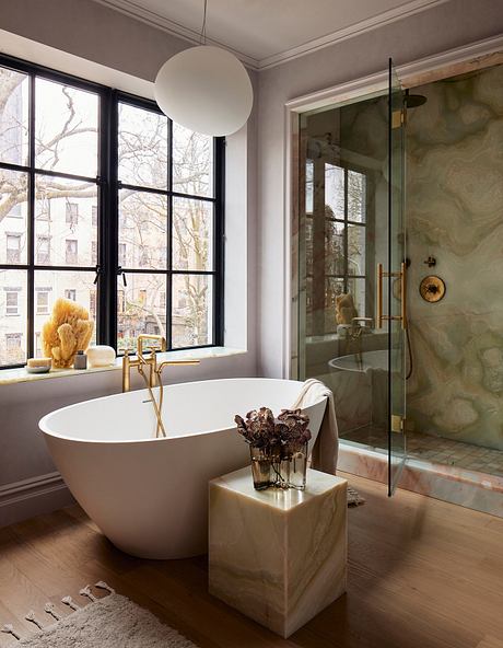 A modern bathroom with a freestanding bathtub, glass shower enclosure, and ornate décor.