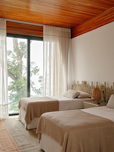 Warm, wooden-paneled ceiling, modern minimalist bedding, and an artful bamboo display.