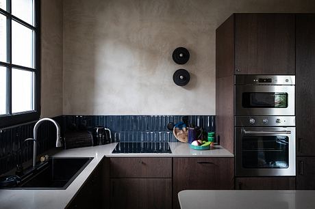 Sleek, modern kitchen with dark cabinets, stainless steel appliances, and minimal decor.