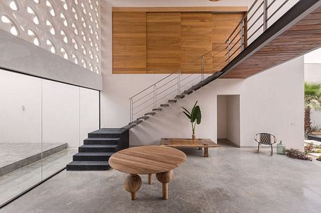 Minimalist entrance with sleek wooden paneling, geometric stairs, and natural materials.