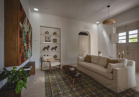 Spacious living room with patterned tile floor, built-in shelves, and plush beige sofa.