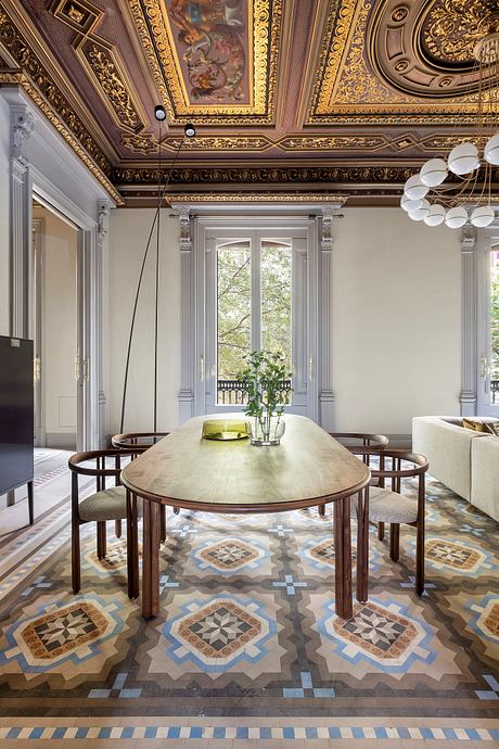 A grand, ornately decorated interior with a patterned tile floor, wooden dining table, and ornate ceiling.