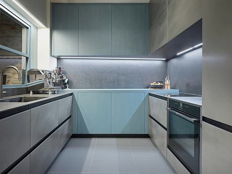 Sleek, minimalist kitchen with gray cabinetry, integrated appliances, and recessed lighting.
