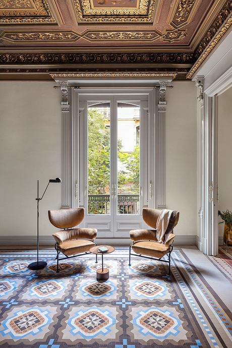Ornate, gilded ceiling frames intricate mosaic floor tiles and leather armchairs.