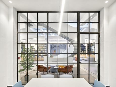 Spacious modern loft with large windows, minimalist furniture, and open-concept layout.